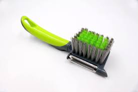 Vegetable and potato peeler with built-in cleaning brush